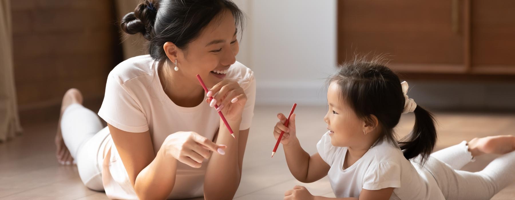 a person and a child writing on a book